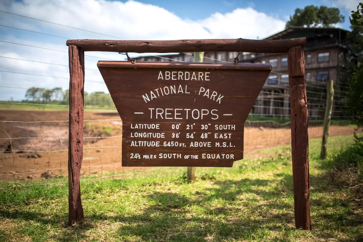 Wooden signboard marking the entrance to Treetops Lodge in Aberdare National Park, Kenya.